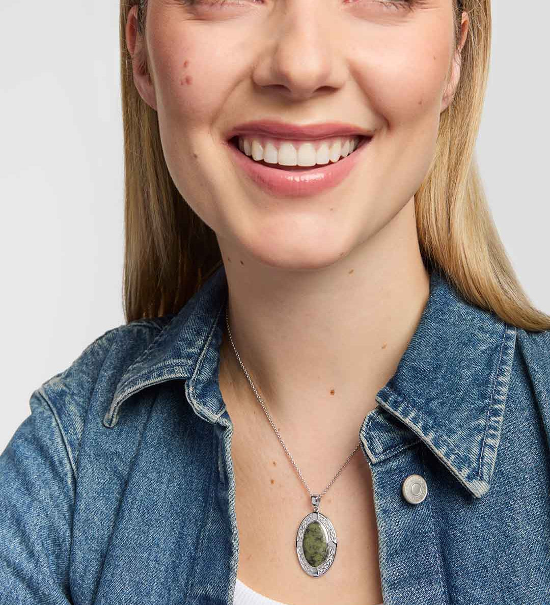 a model wearing Connemara marble Celtic shield pendant with Celtic knotwork crafted in polished silver detailing on a silver chain