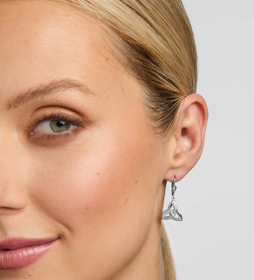 close-up image of a female model wearing Celtic Trinity Knot earrings in silver