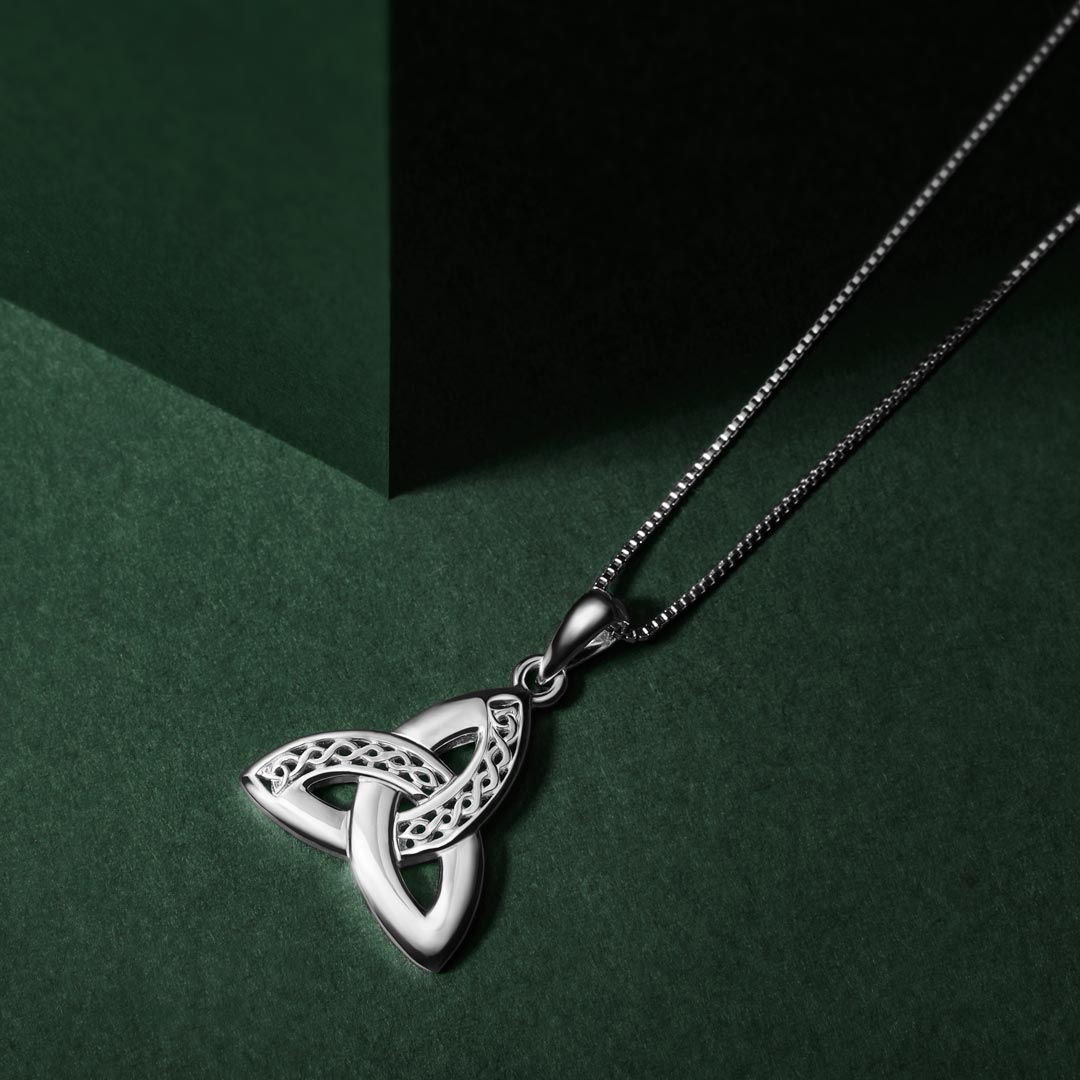 lifestyle image of silver celtic trinity knot pendant. Three gently curved loops intertwine seamlessly creating the iconic triangular knot shape, symbolising an unbroken connection with no beginning or end.