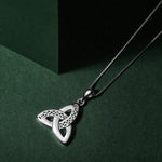 lifestyle image of silver celtic trinity knot pendant. Three gently curved loops intertwine seamlessly creating the iconic triangular knot shape, symbolising an unbroken connection with no beginning or end.