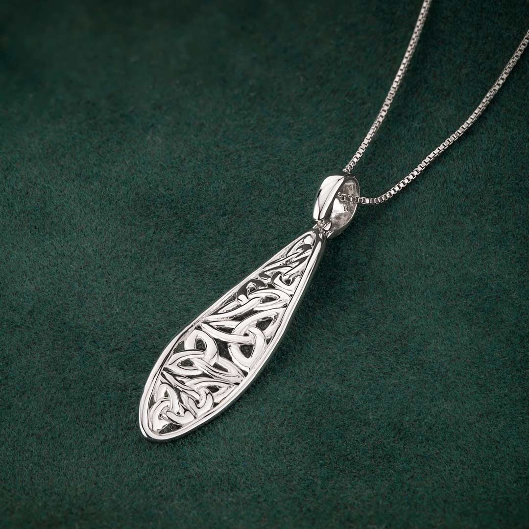 lifestyle image of celtic twist trinity knot pendant on dark green background