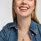 model wearing a polished silver Trinity Knot  pendant entwined around a circular green marble inlay, combining flowing Celtic lines with a clean, openwork finish.