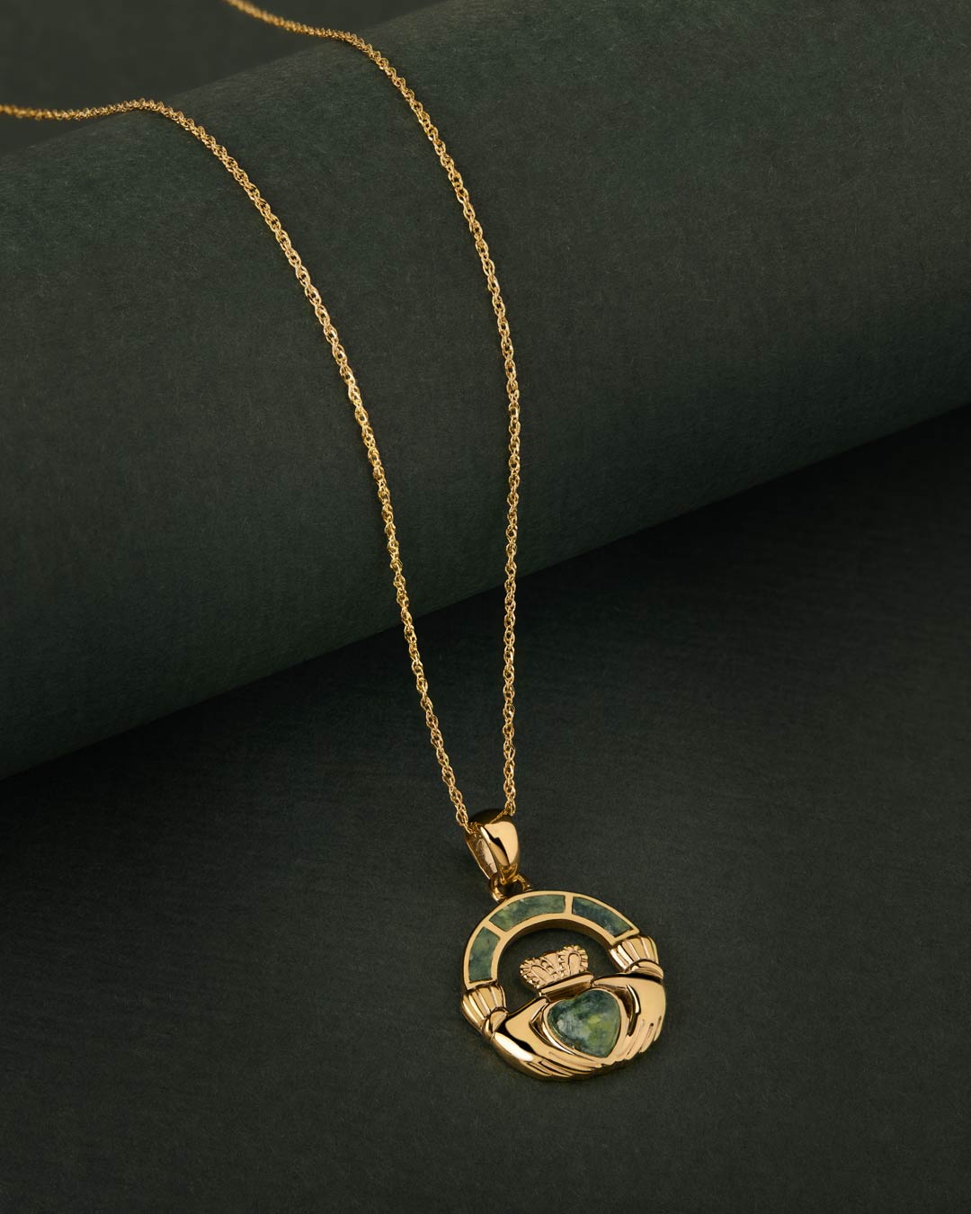 Connemara Marble gold Claddagh necklace on green background