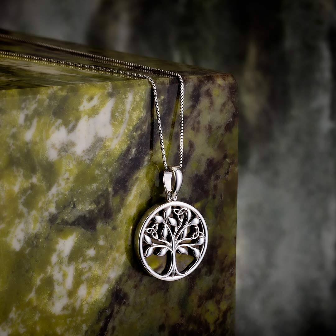 lifestyle image of silver connemara marble tree of life necklace s46669 on green marble stone