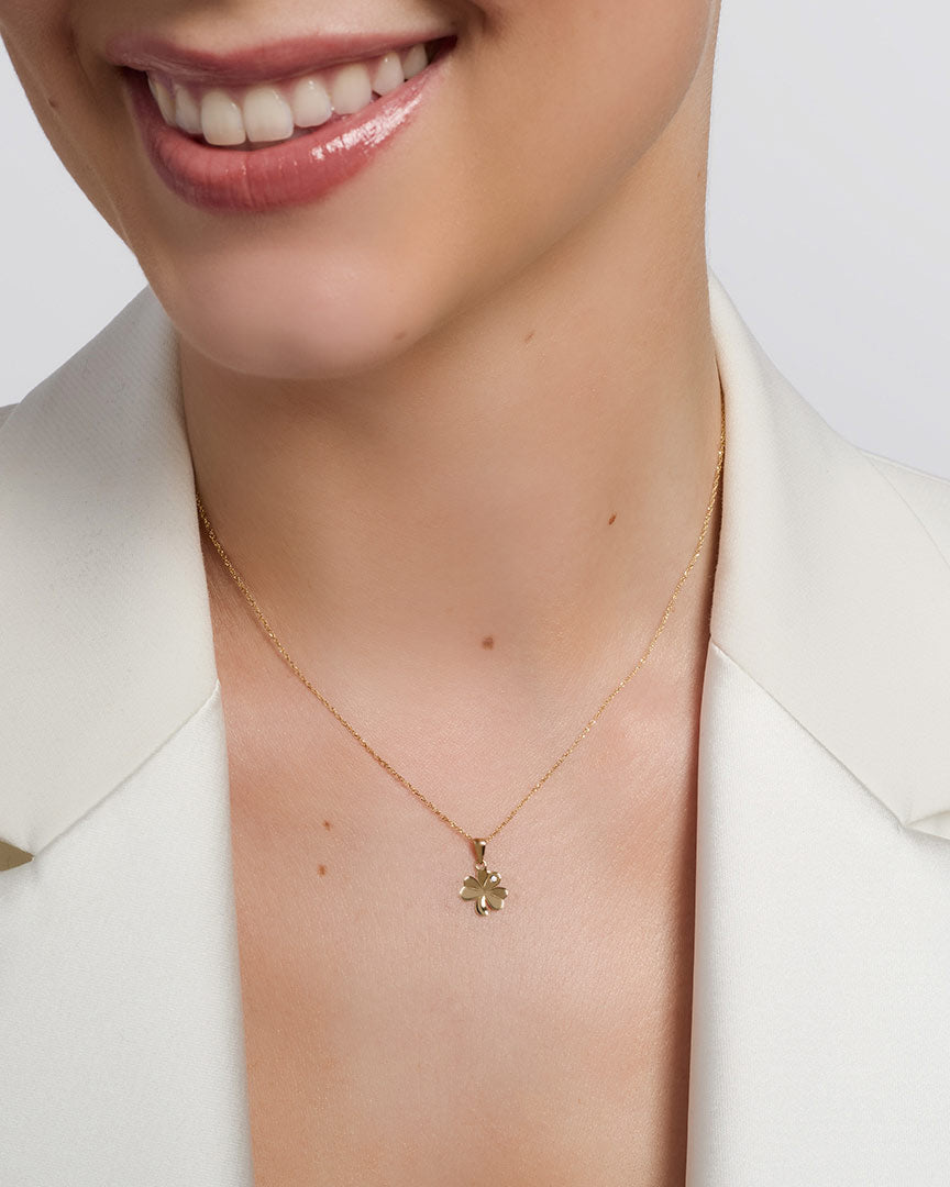 yellow gold cz shamrock necklace presented on a model