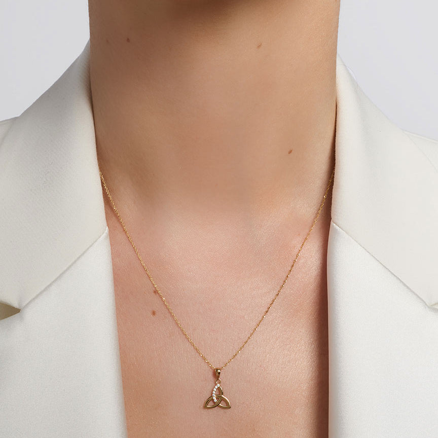 yellow gold cz trinity knot necklace presented on a model