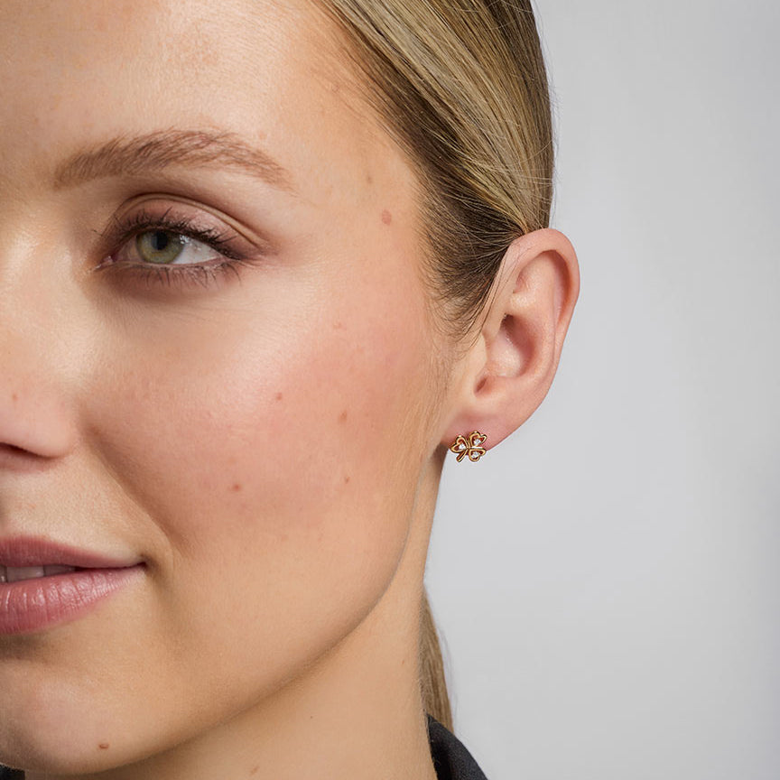 close-up image of a model wearing gold diamond shamrock earrings s33482 