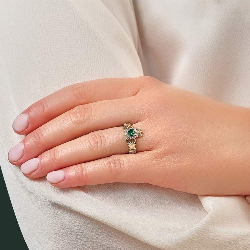 a model wearing gold emerald & gold claddagh ring s21030