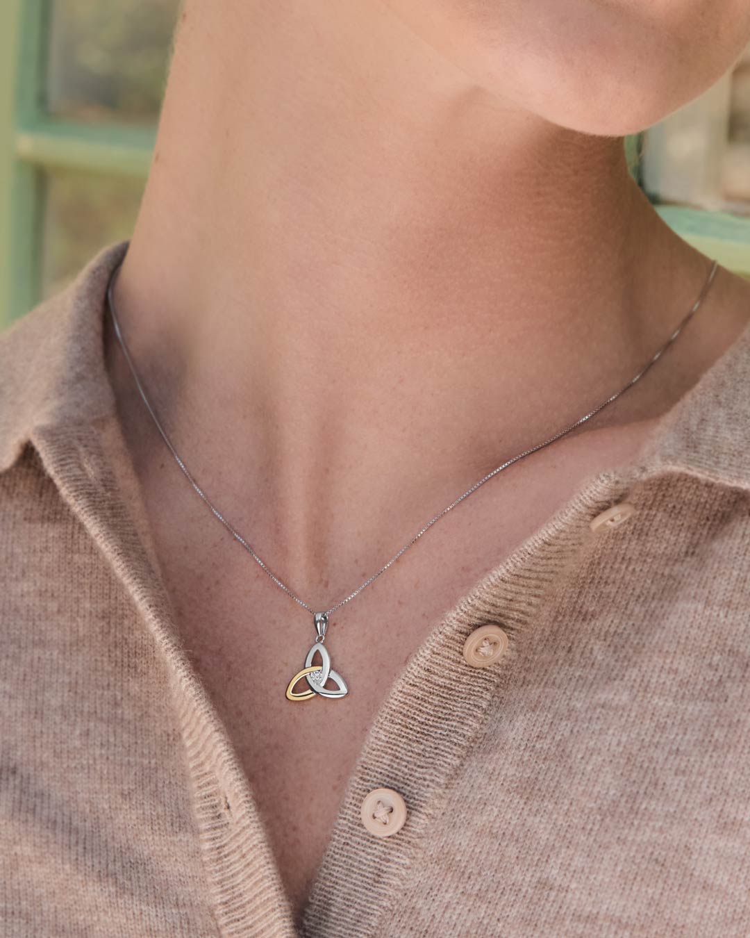 a model wearing gold and silver trinity knot necklace s45347