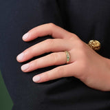 a model wearing gold diamond and emerald claddagh eternity ring