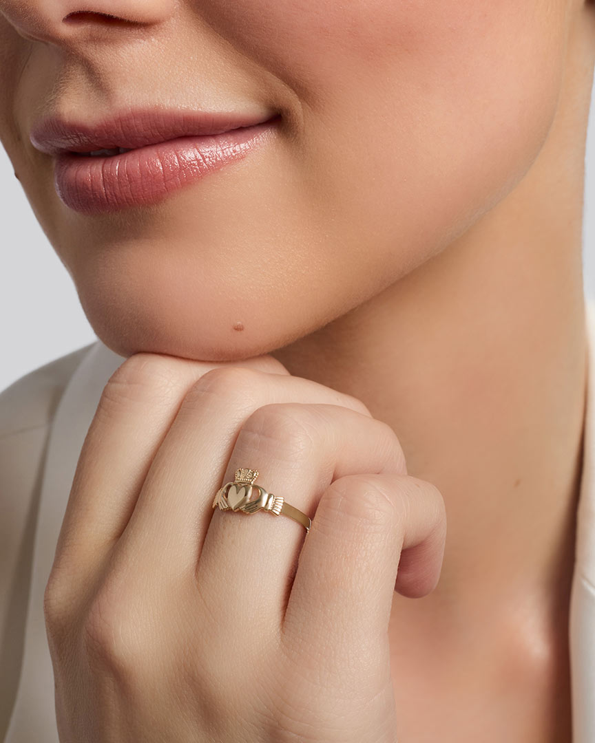 gold mini Claddagh ring on a model's hand 1