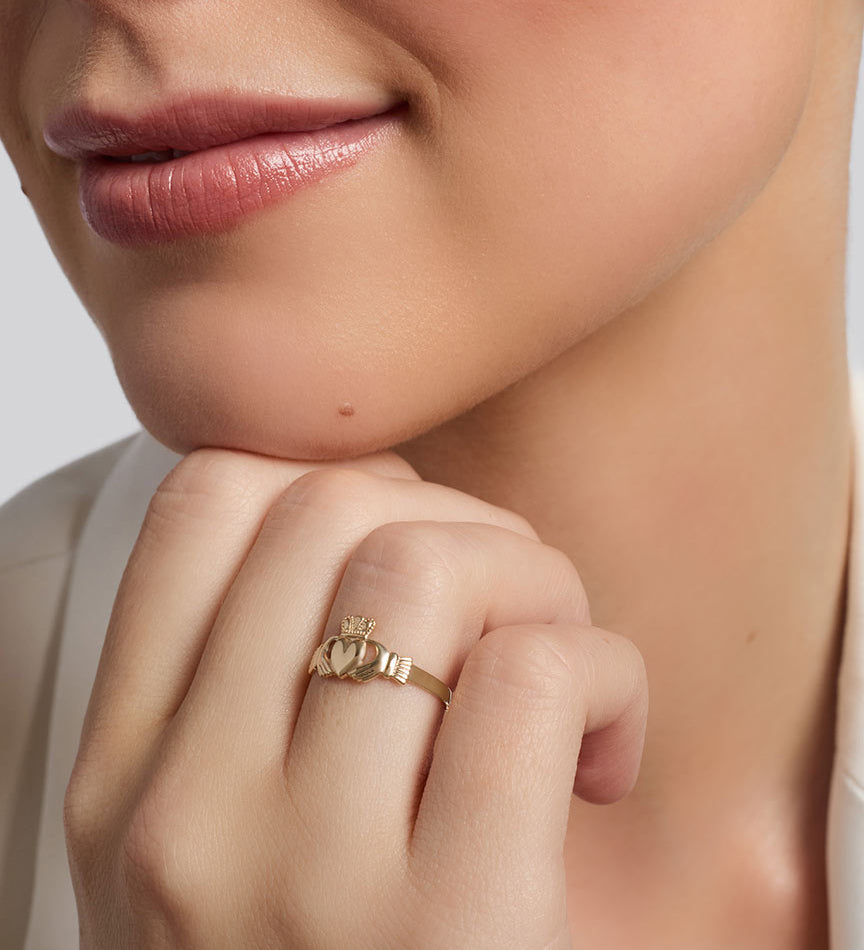 gold mini Claddagh ring on a model's hand 1