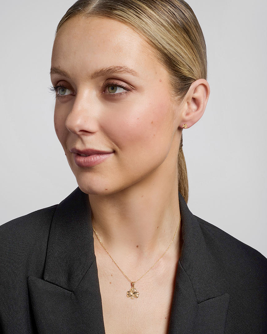 model wearing gold shamrock stud earrings