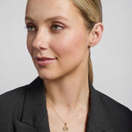 model wearing gold shamrock stud earrings