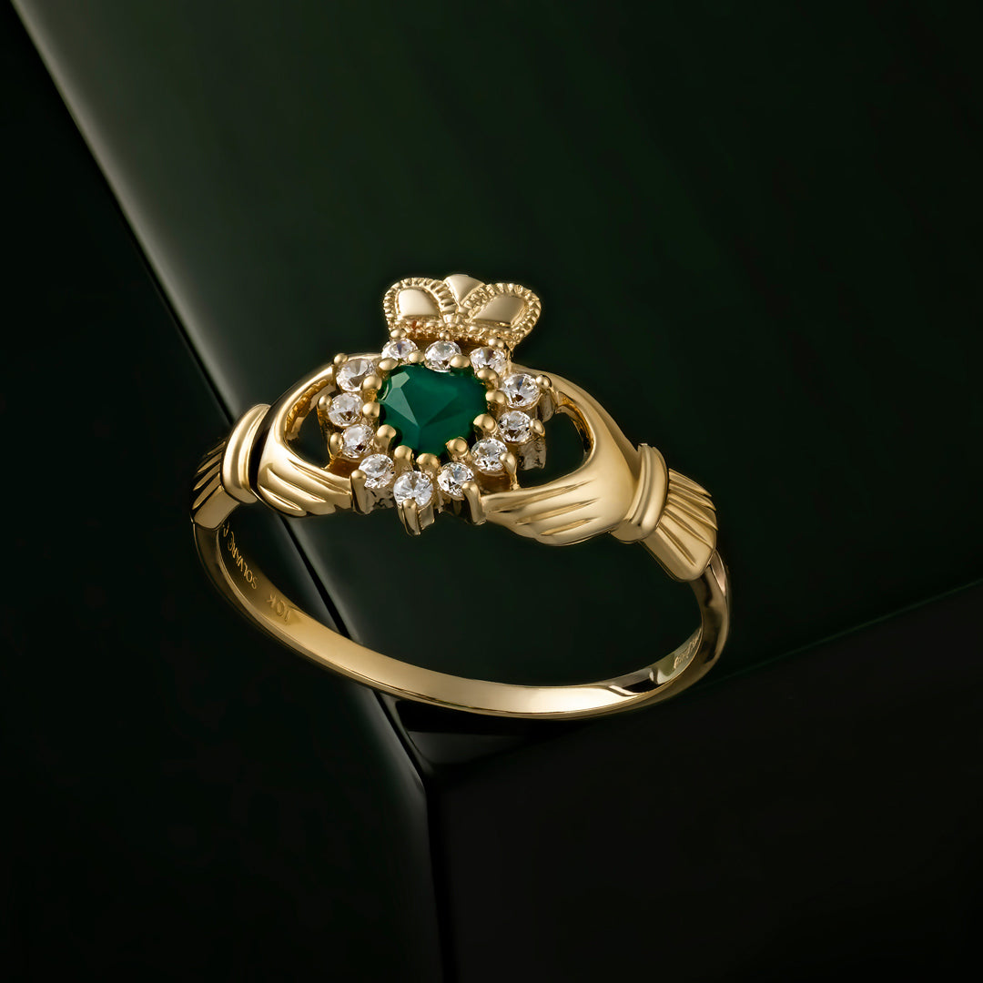 styled image of Solvar green agate Claddagh ring on a dark green background