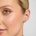 close-up of small claddagh stud earrings on a model