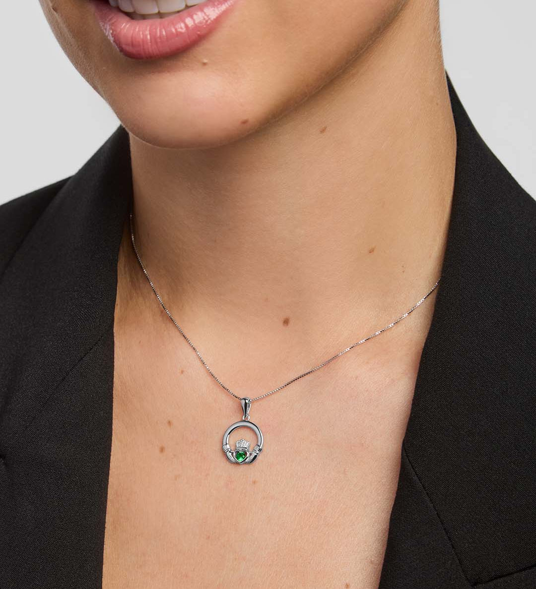 Claddagh necklace with a green stone  centre on a female model