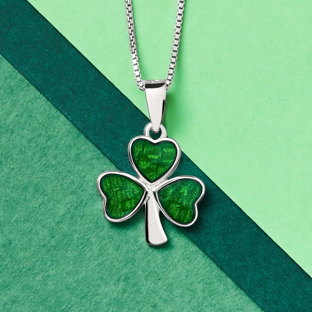 closeup image of green enamel shamrock pendant on green background