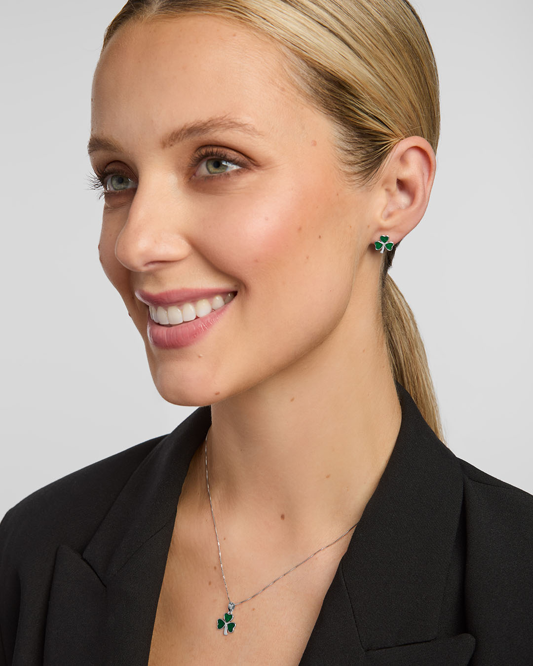 Female model wearing matching shamrock earrings and a necklace set from Solvar