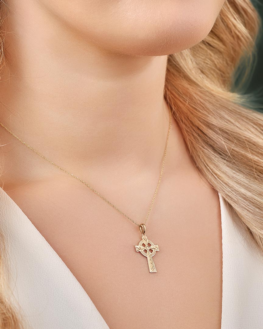 a model wearing hand engraved gold celtic cross necklace