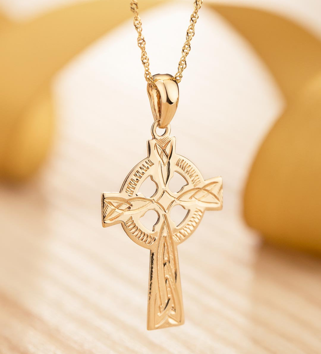 lifestyle image of hand engraved gold celtic cross necklace 1