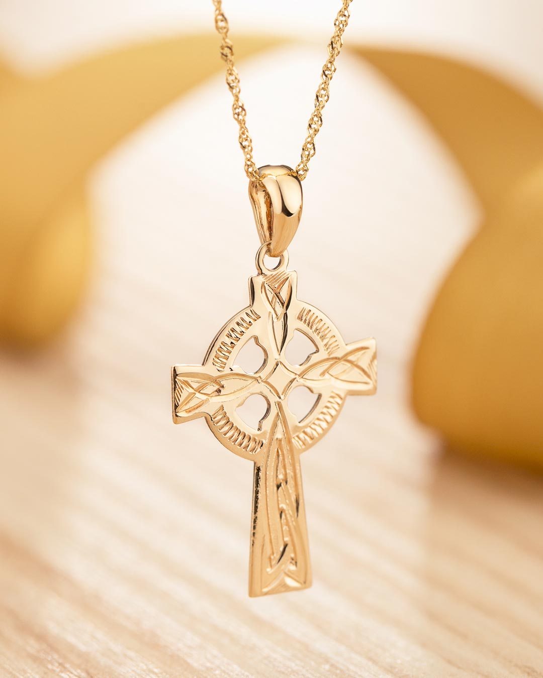 lifestyle image of hand engraved gold celtic cross necklace