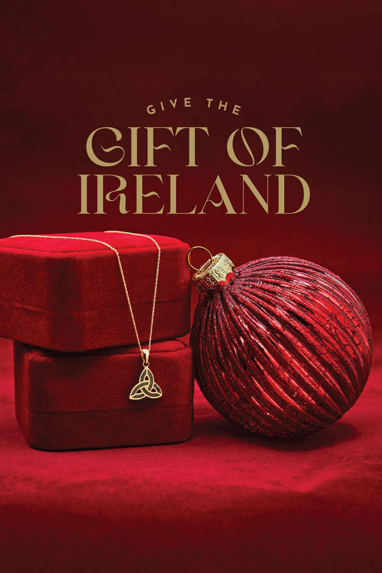 Red gift box, gold Trinity Knot necklace, and Christmas ball with 'Give the Gift of Ireland' text on a red background