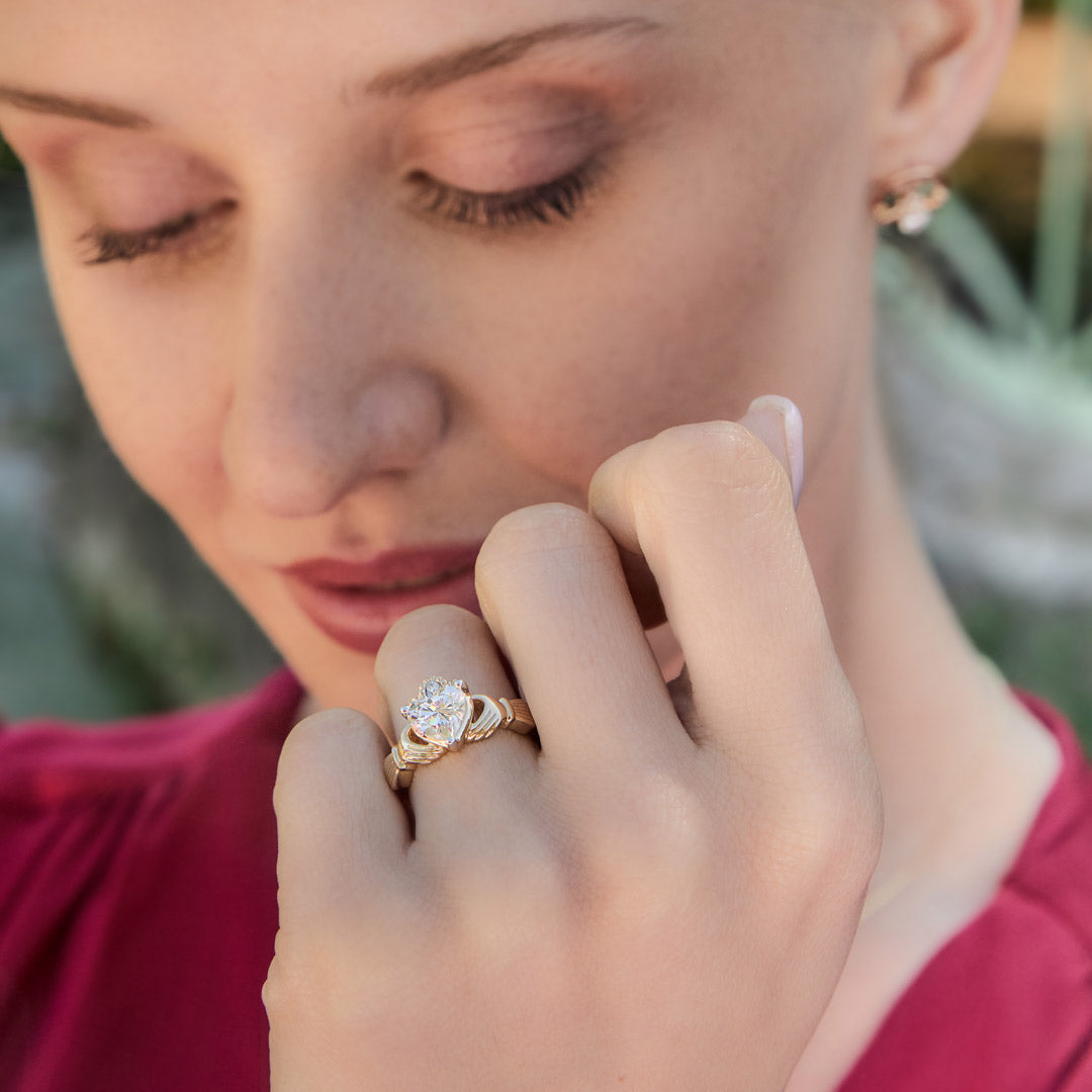 closeup image of diamond claddagh ring on model's hand