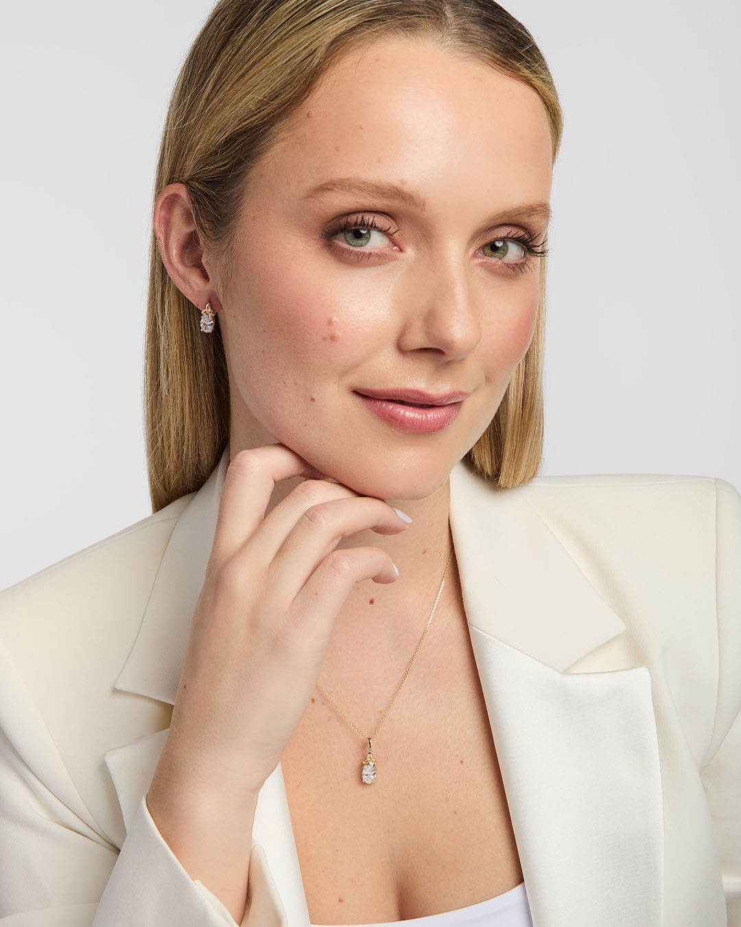 Model wearing matching gold Trinity Knot necklace and earrings with lab-grown diamonds