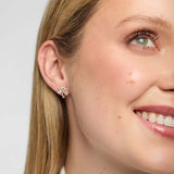 Close-up of model wearing gold Shamrock stud earring with lab-grown diamond