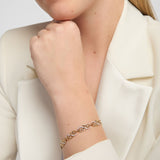 close-up image of yellow gold Celtic knot bracelet featuring a repeating pattern of openwork interlaced knots. Sections of the knotwork are accented with diamond set