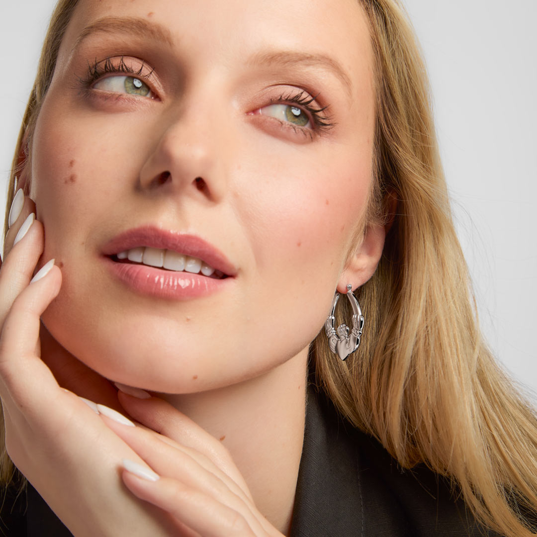 large silver claddagh hoop earrings on a model