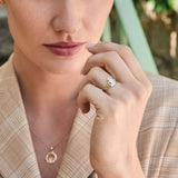 close-up image of woman wearing Claddagh ring in yellow gold