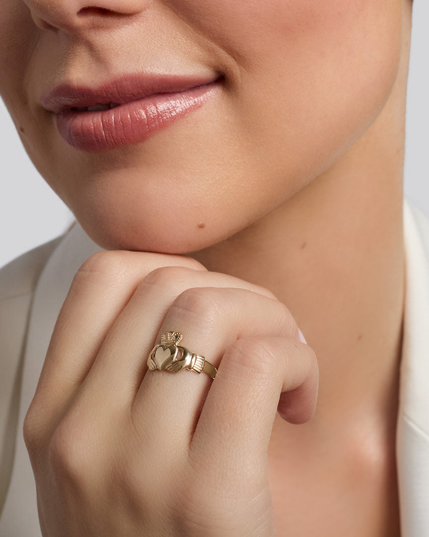 leight weight traditional gold Claddagh ring on a model