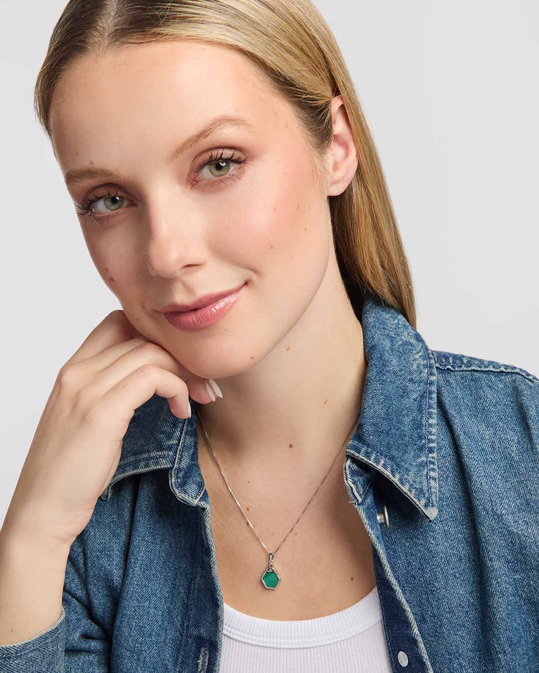 A striking green malachite stone framed in polished sterling silver, with an openwork Trinity Knot forming an elegant Celtic detail above the stone presented on a model
