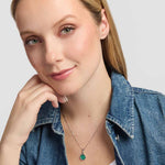 A striking green malachite stone framed in polished sterling silver, with an openwork Trinity Knot forming an elegant Celtic detail above the stone presented on a model