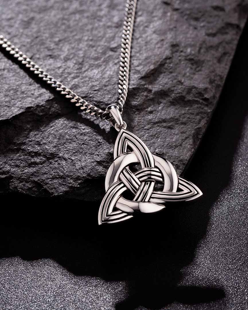 lifestyle image of mens heavy celtic knot pendant on dark background