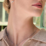 Close-up of a woman wearing Celtic Trinity Knot earrings and necklace set from Solvar