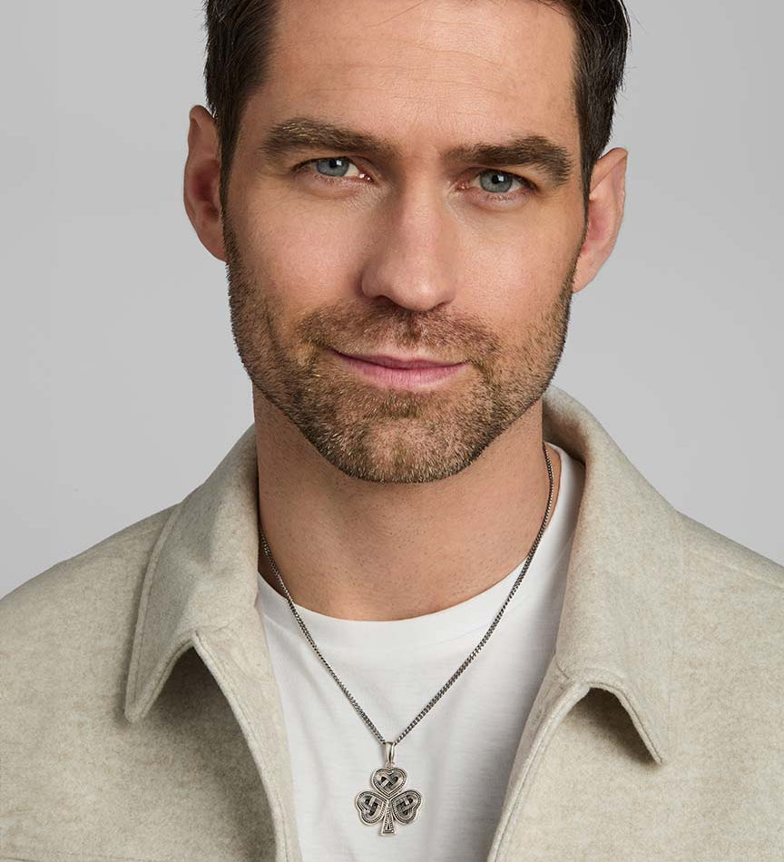 a model wearing men's silver Celtic Shamrock pendant on heavy silver chain from Solvar
