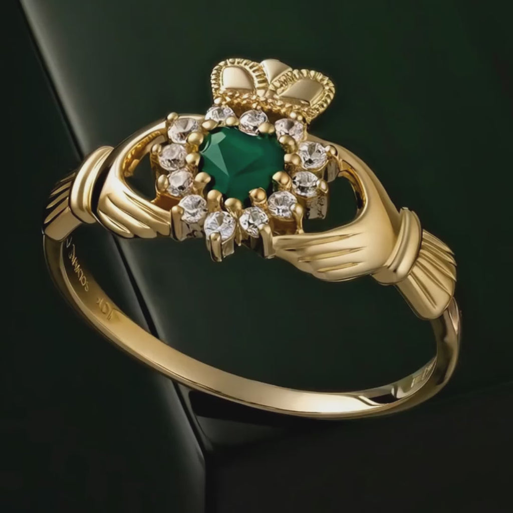 Gold Claddagh ring with Green Agate centre rotating on dark green background
