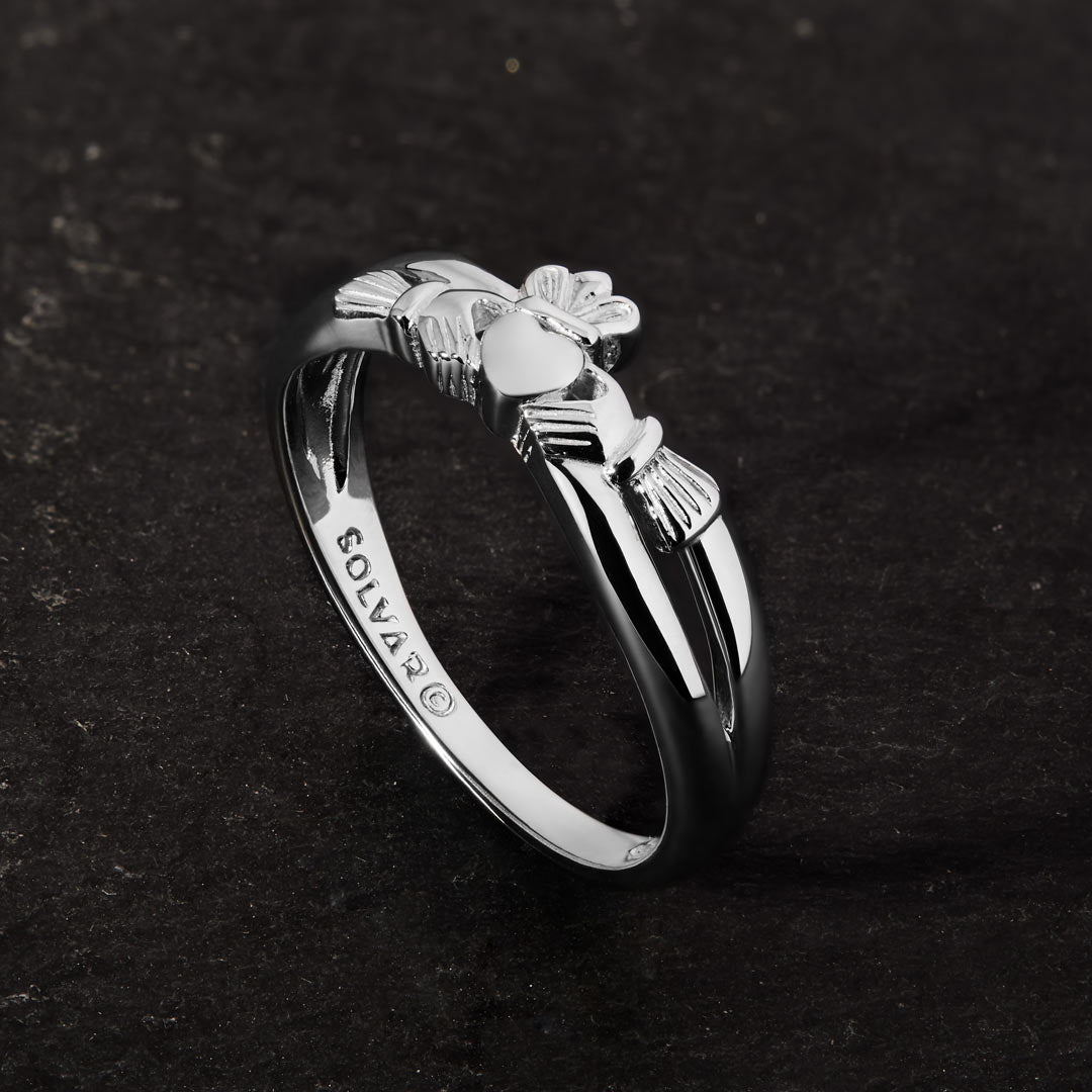 lifestyle image of promise Claddagh ring on a dark stone background