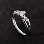 lifestyle image of promise Claddagh ring on a dark stone background