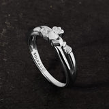 lifestyle image of promise Claddagh ring on a dark stone background
