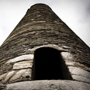 Celtic stone tower on the dark sky background