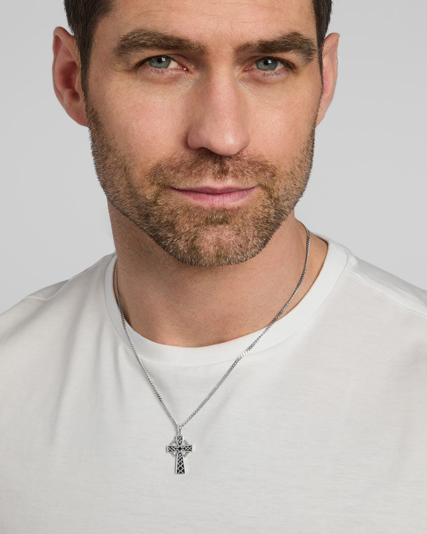 a male model wearing oxidised silver Celtic cross pendant on a heavy chain from Solvar
