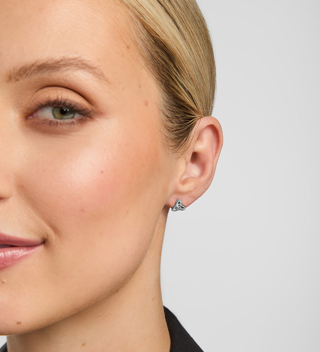 small silver trinity knot stud earrings on a model