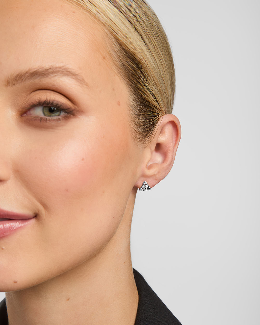 small silver trinity knot stud earrings on a model