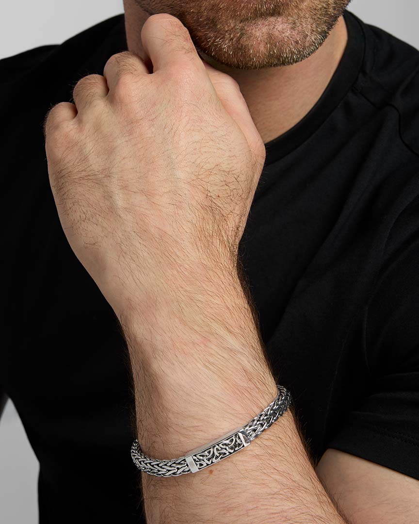 closeup image of men's heavy Celtic Trinity Knot bracelet in silver on a model