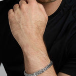 closeup image of men's heavy Celtic Trinity Knot bracelet in silver on a model