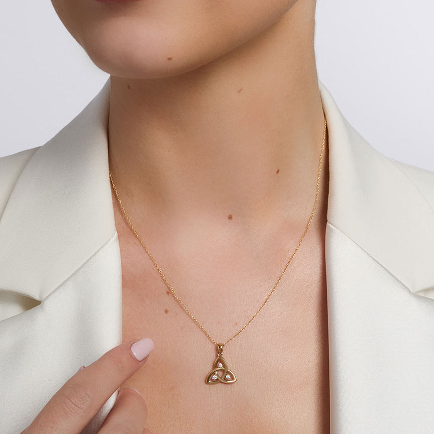 open cz gold trinity knot pendant on a model 1